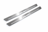 Product visualization: Ford Kuga logo, two exact matching source plates flat brushed stainless steel door sill plates with white LED artwork and edges, white background.