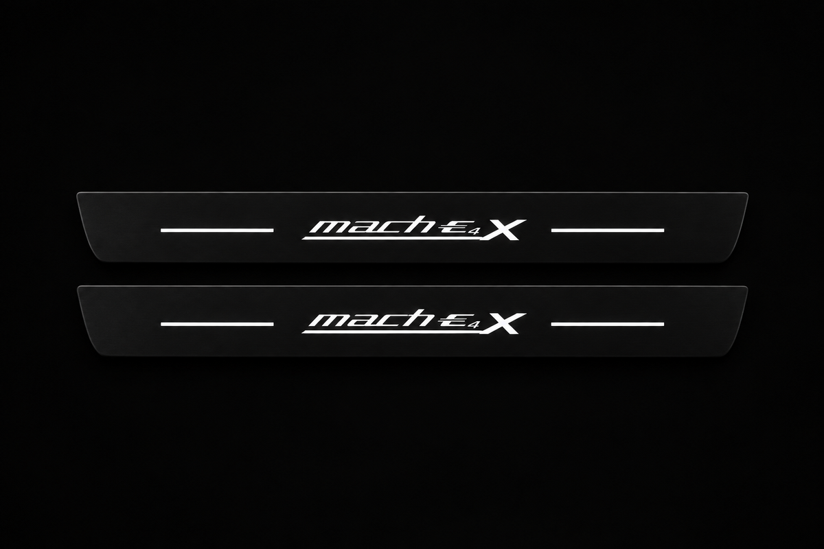 Catalogue illustration of two black Matte PRO front door sill plates with stylized white mach E 4 X lettering and thin horizontal lines illuminated only on top. Rear plates for FRONT+REAR are not pictured; dimensions are selected for the vehicle during manufacture.