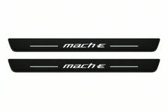 Catalogue illustration of two front black Matte PRO LED door sill plates with illuminated Mach-E lettering for Ford Mustang Mach-E CX727; dimensions are selected during manufacture.