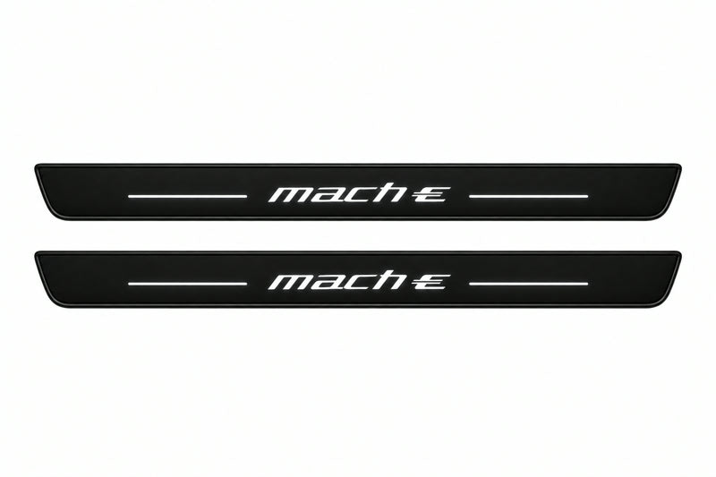 Catalogue illustration of two front black Matte PRO LED door sill plates with illuminated Mach-E lettering for Ford Mustang Mach-E CX727; dimensions are selected during manufacture.