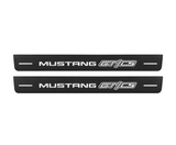 Matte PRO catalogue illustration showing two FRONT plates with illuminated Mustang GT/CS lettering on a white background; Ford Mustang V S197 dimensions are selected during manufacture; rear plates are not pictured.