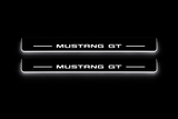 Product visualization: two exact original s650-mustang-gt flat Stainless front plates; all source artwork retained and actual LED edges white flat brushed stainless steel door sill plates with white LED artwork and edges, dark background.