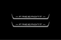 Two long door sill plates with Freemont lettering and edges illuminated in white, straight-on view on a dark background.