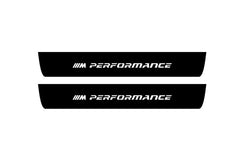 Catalog illustration of two black front door sill plates with ///M Performance lettering.