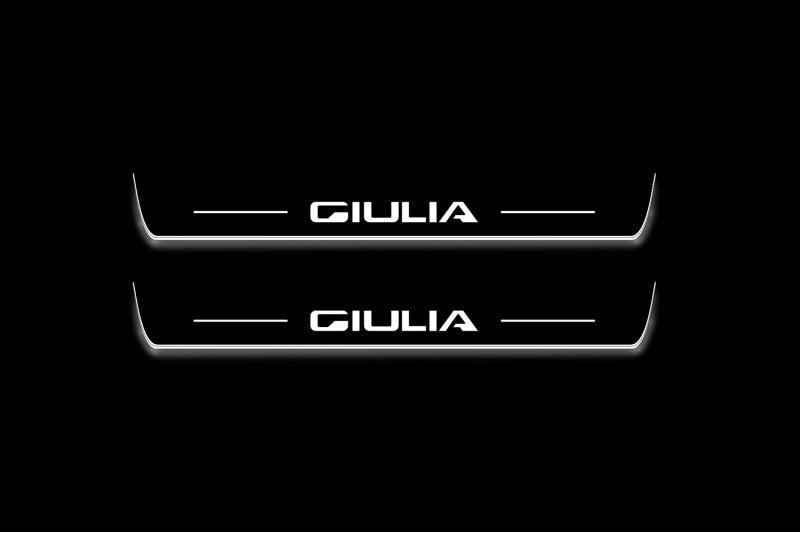 Two short door sill plates with Giulia lettering and edges illuminated in white, straight-on view on a dark background.