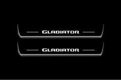 Two long door sill plates with Gladiator lettering and edges illuminated in white, straight-on view on a dark background.