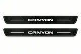 Catalogue illustration of two front black Matte PRO LED door sill plates with illuminated Canyon lettering for GMC Canyon II; dimensions are selected during manufacture.