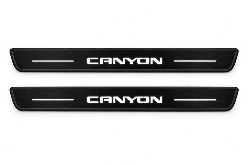 Catalogue illustration of two front black Matte PRO LED door sill plates with illuminated Canyon lettering for GMC Canyon II; dimensions are selected during manufacture.