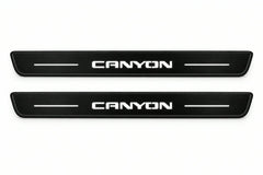 Catalogue illustration of two front black Matte PRO LED door sill plates with illuminated Canyon lettering for GMC Canyon III GMT31; dimensions are selected during manufacture.