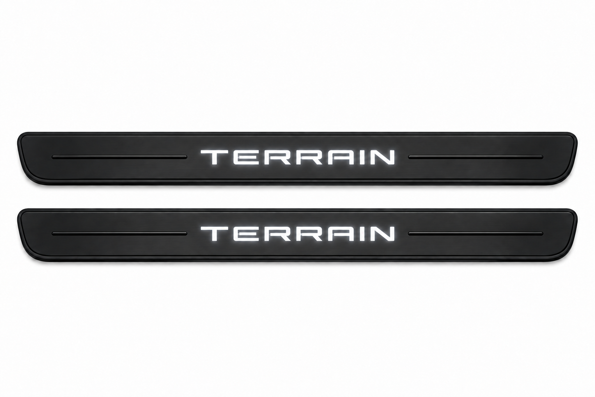 Catalogue illustration of two black Matte PRO front door sill plates with illuminated TERRAIN lettering on the upper surface. One decorative line on each side remains unlit; rear plates for FRONT+REAR are not pictured. Dimensions are selected for GMC Terrain II C1 during manufacture.