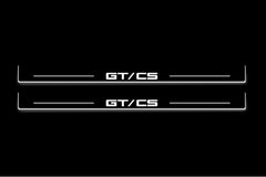 Two long door sill plates with GT/CS lettering and edges illuminated in white, straight-on view on a dark background.