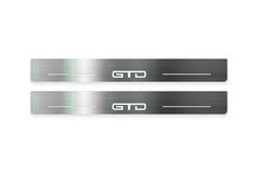 Two long silver-finished door sill plates with GTD lettering on a light background, straight-on view.
