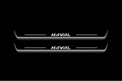 Two long door sill plates with Haval lettering and edges illuminated in white, straight-on view on a dark background.