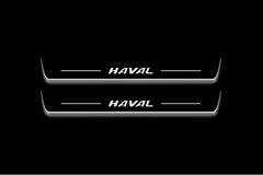 Two long door sill plates with Haval lettering and edges illuminated in white, straight-on view on a dark background.