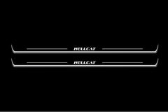 Two long door sill plates with Hellcat lettering and edges illuminated in white, straight-on view on a dark background.