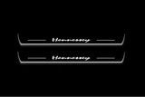 Two long door sill plates with Hennessey lettering and edges illuminated in white, straight-on view on a dark background.