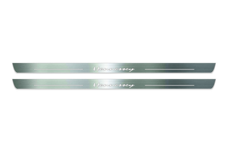Two long silver-finished door sill plates with Hennessey lettering on a light background, straight-on view.