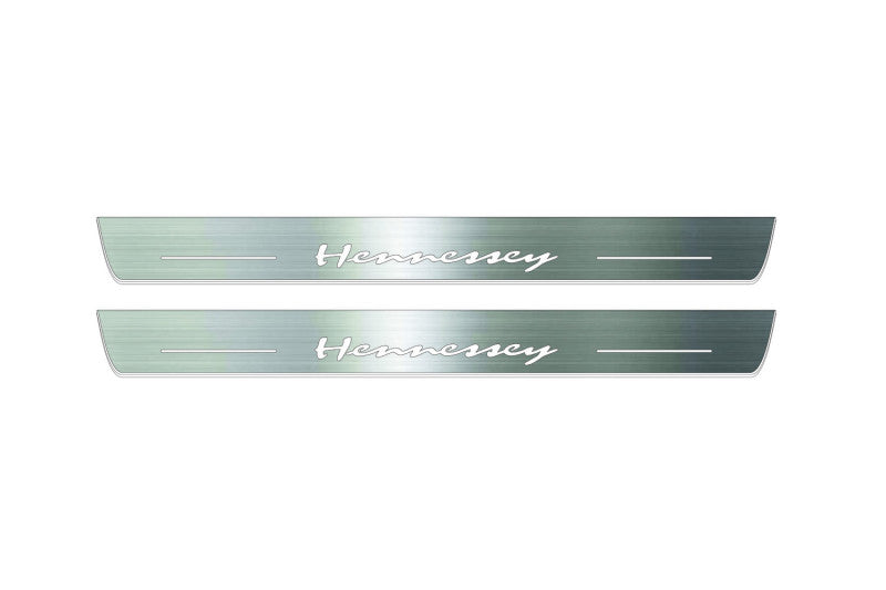 Two long silver-finished door sill plates with Hennessey lettering on a light background, straight-on view.