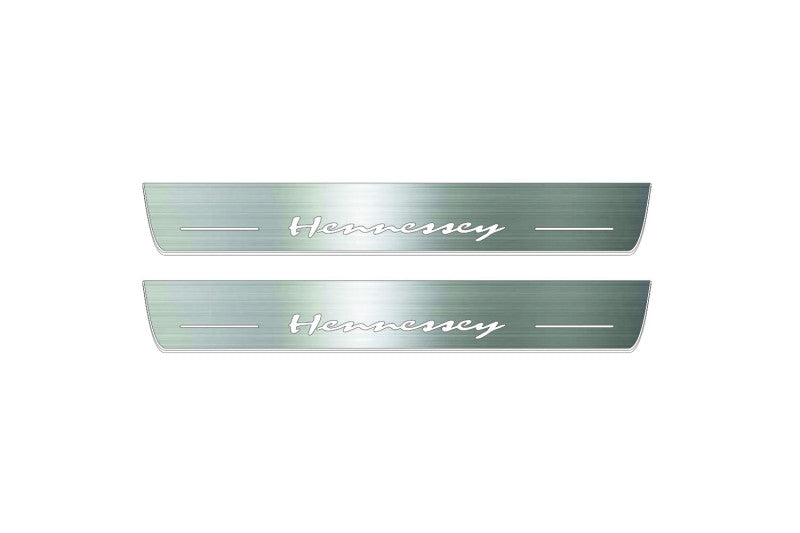 Two long silver-finished door sill plates with Hennessey lettering on a light background, straight-on view.