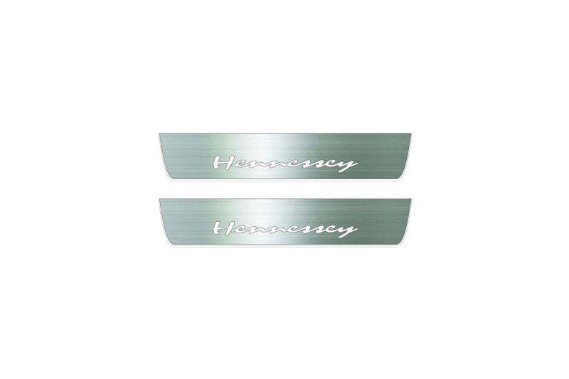 Two short silver-finished door sill plates with Hennessey lettering on a light background, straight-on view.