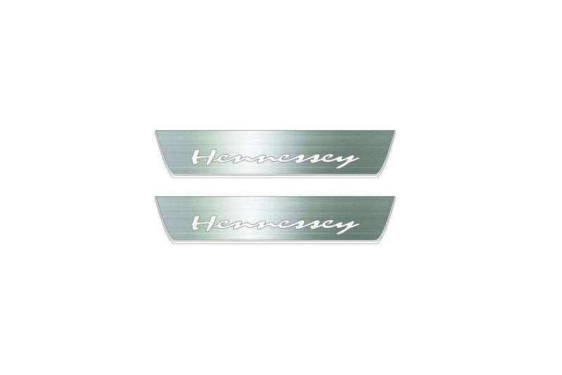 Two short silver-finished door sill plates with Hennessey lettering on a light background, straight-on view.