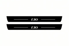 Catalogue illustration of two front black Matte PRO LED door sill plates with illuminated i30 lettering for Hyundai i30 III; dimensions are selected during manufacture.