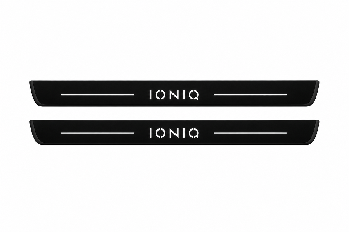 Catalogue illustration of two black Matte PRO front door sill plates with illuminated white IONIQ lettering and thin top light lines. The edges remain unlit. Rear plates for FRONT+REAR are not pictured; dimensions are selected for the vehicle during manufacture.