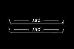 Two long door sill plates with i30 lettering and edges illuminated in white, straight-on view on a dark background.