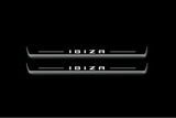 Two long door sill plates with Ibiza in block lettering lettering and edges illuminated in white, straight-on view on a dark background.