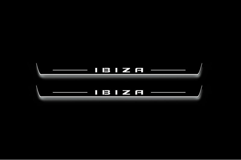 Two long door sill plates with Ibiza in block lettering lettering and edges illuminated in white, straight-on view on a dark background.