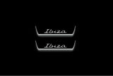 Two short door sill plates with Ibiza in script lettering and edges illuminated in white, straight-on view on a dark background.