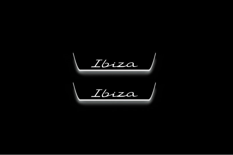 Two short door sill plates with Ibiza in script lettering and edges illuminated in white, straight-on view on a dark background.