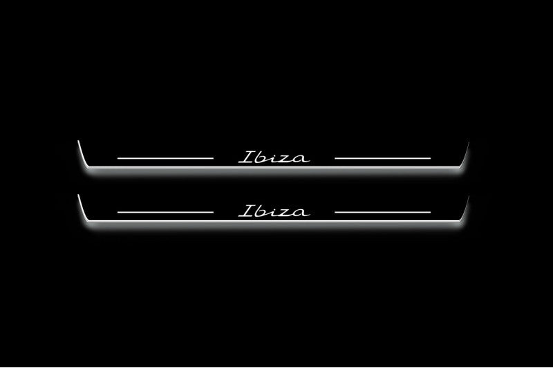 Two long door sill plates with Ibiza in script lettering and edges illuminated in white, straight-on view on a dark background.