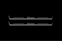 Two long door sill plates with Ibiza in script lettering and edges illuminated in white, straight-on view on a dark background.