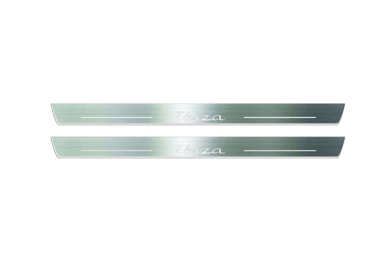 Two long silver-finished door sill plates with Ibiza in script lettering on a light background, straight-on view.