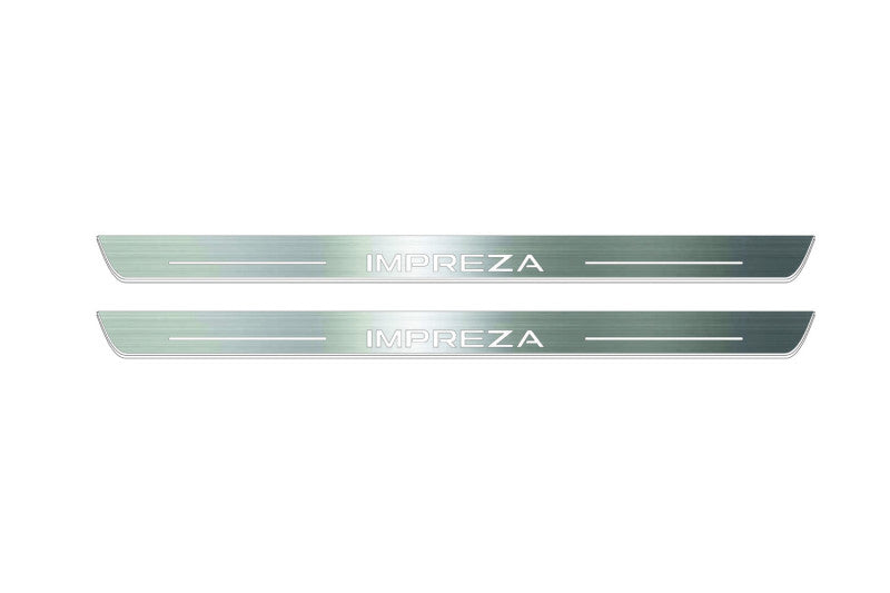 Two long silver-finished door sill plates with Impreza lettering on a light background, straight-on view.