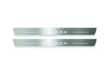 Two long silver-finished door sill plates with Impreza lettering on a light background, straight-on view.
