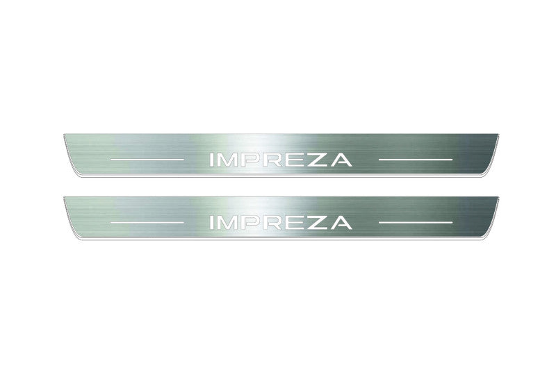 Two long silver-finished door sill plates with Impreza lettering on a light background, straight-on view.