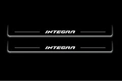 Two long door sill plates with Integra lettering and edges illuminated in white, straight-on view on a dark background.