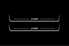 Two long door sill plates with Jazz lettering and edges illuminated in white, straight-on view on a dark background.
