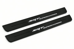 Catalogue illustration of two front black Matte PRO LED door sill plates with illuminated SRT Supercharged lettering for Jeep Grand Cherokee WK2; dimensions are selected during manufacture.
