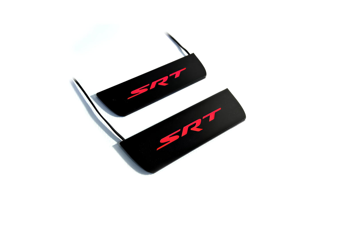 Two black door sill plates with red SRT lettering and visible wiring on a light background.