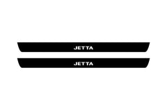 Catalog illustration of two black front door sill plates with Jetta lettering.