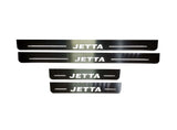 Four reflective door sill plates with white Jetta lettering and horizontal lines.