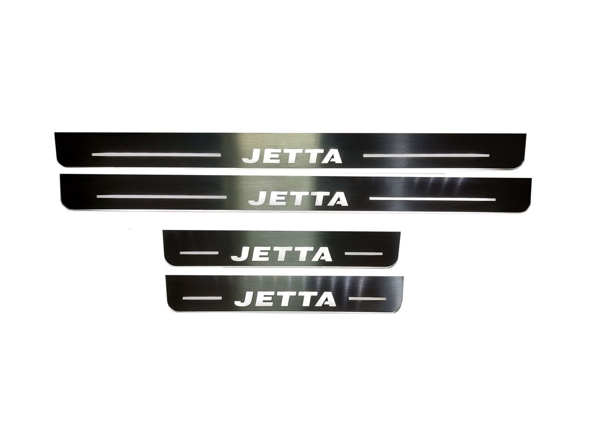 Four reflective door sill plates with white Jetta lettering and horizontal lines.