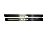 Two long reflective door sill plates with white Jetta lettering and horizontal lines.