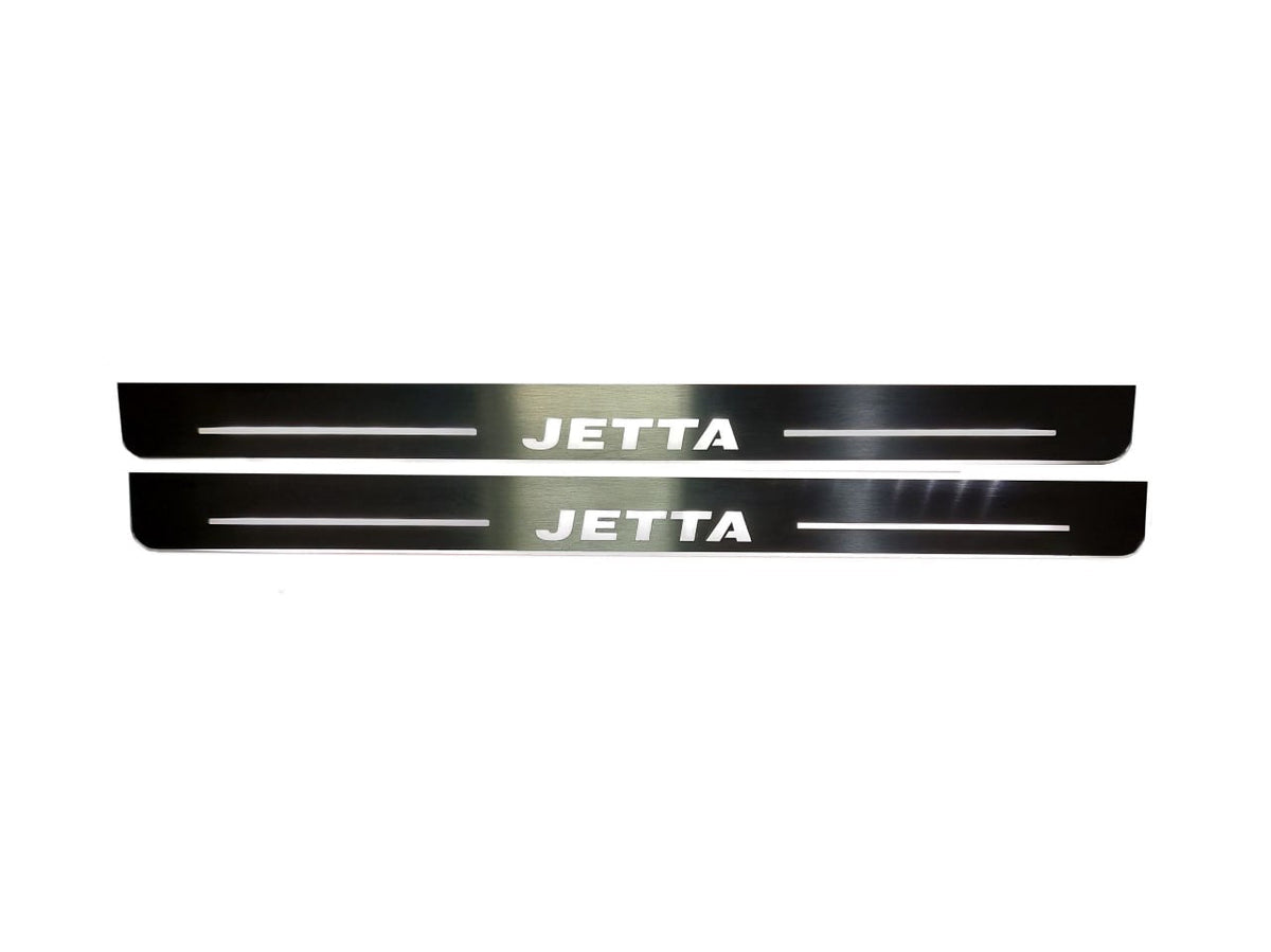 Two long reflective door sill plates with white Jetta lettering and horizontal lines.