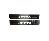 Two short reflective door sill plates with white Jetta lettering and horizontal lines.