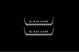 Two short door sill plates with Kadjar lettering and edges illuminated in white, straight-on view on a dark background.