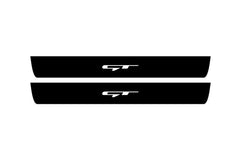 Catalog illustration of two black front door sill plates with GT lettering.